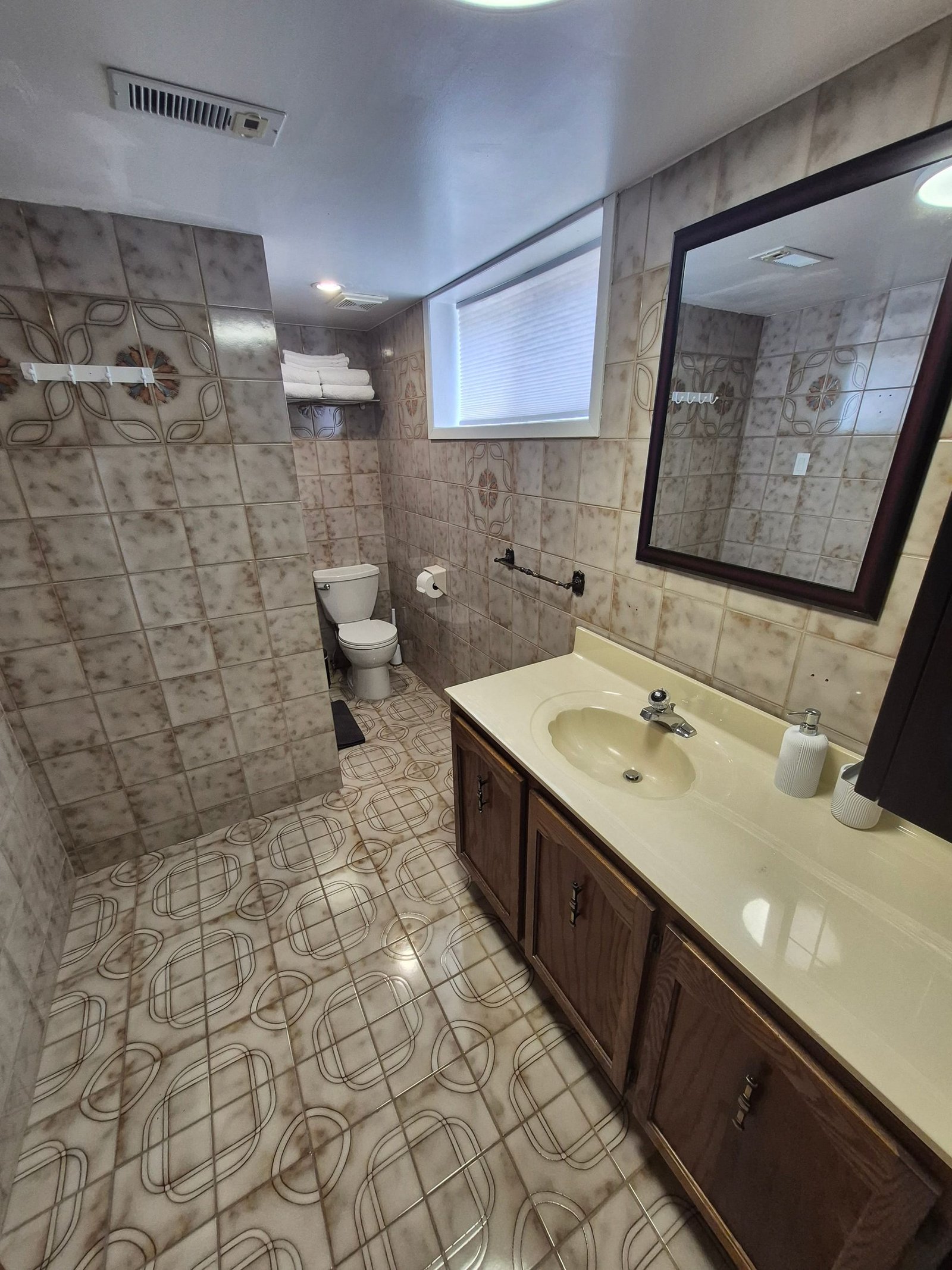 Bathroom with vanity, mirror, toilet, and tiled shower enclosure