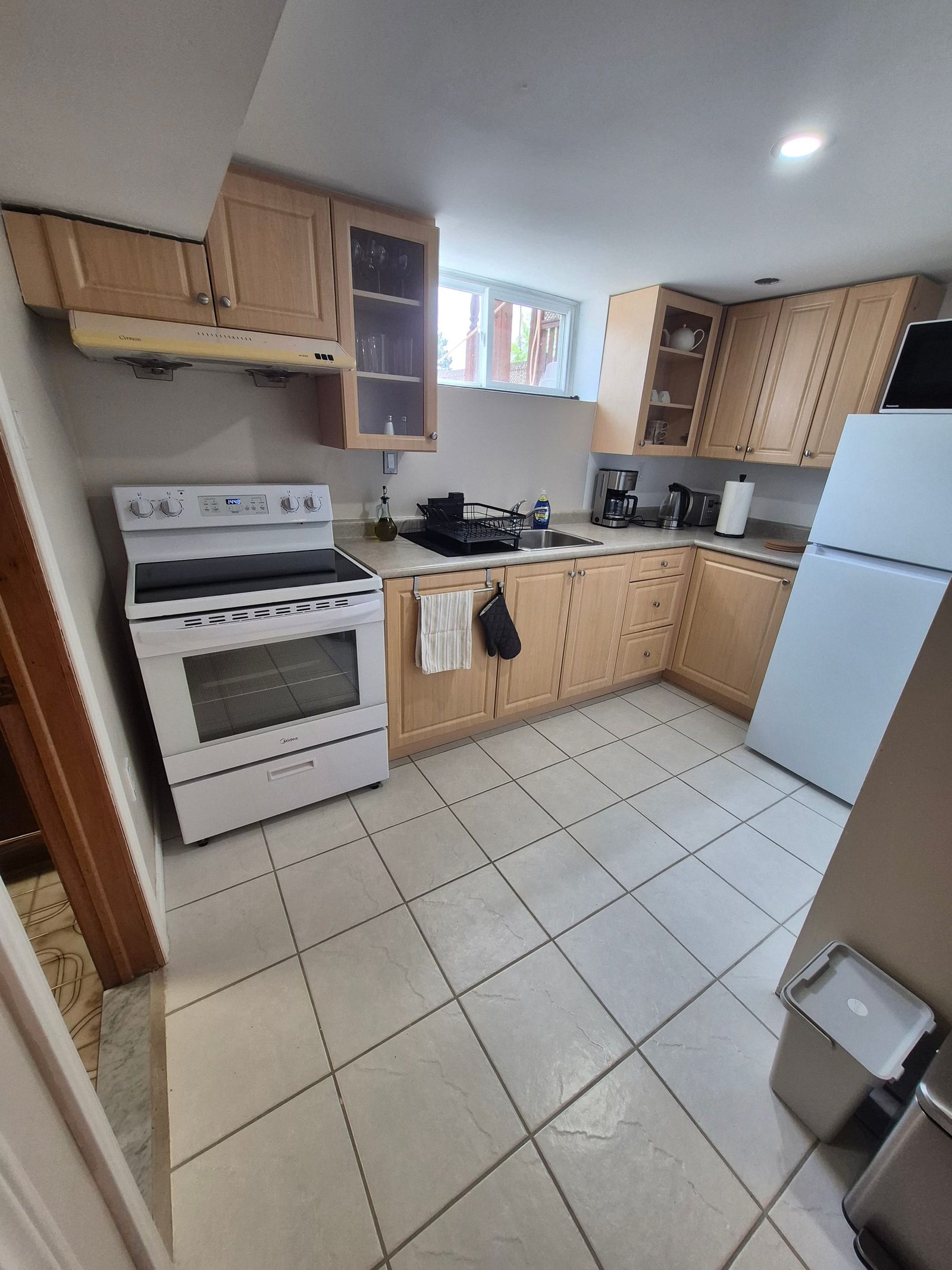 Kitchen with stove, refrigerator, sink, and countertop appliances