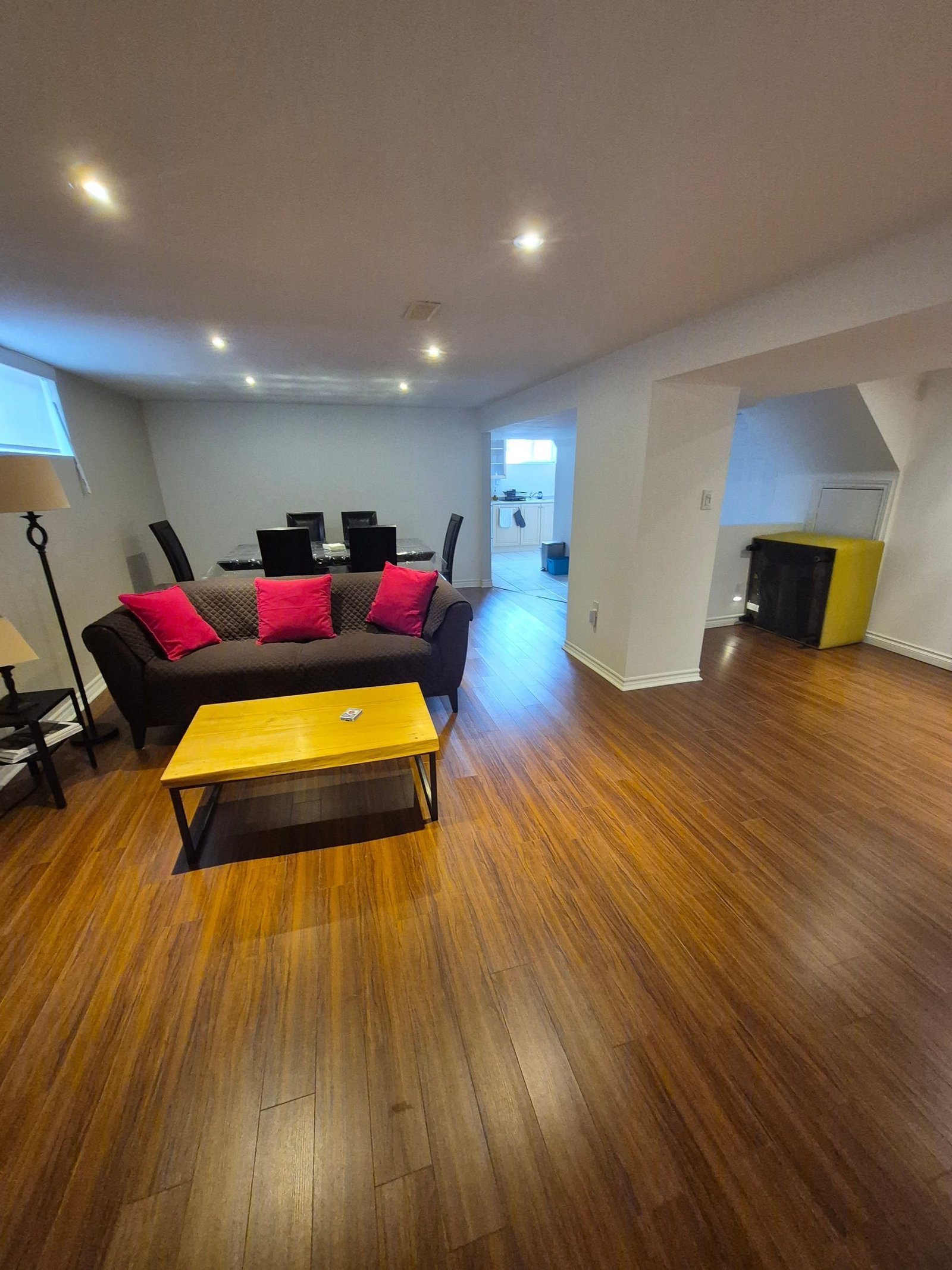 Living area with sofa, coffee table, and dining space behind